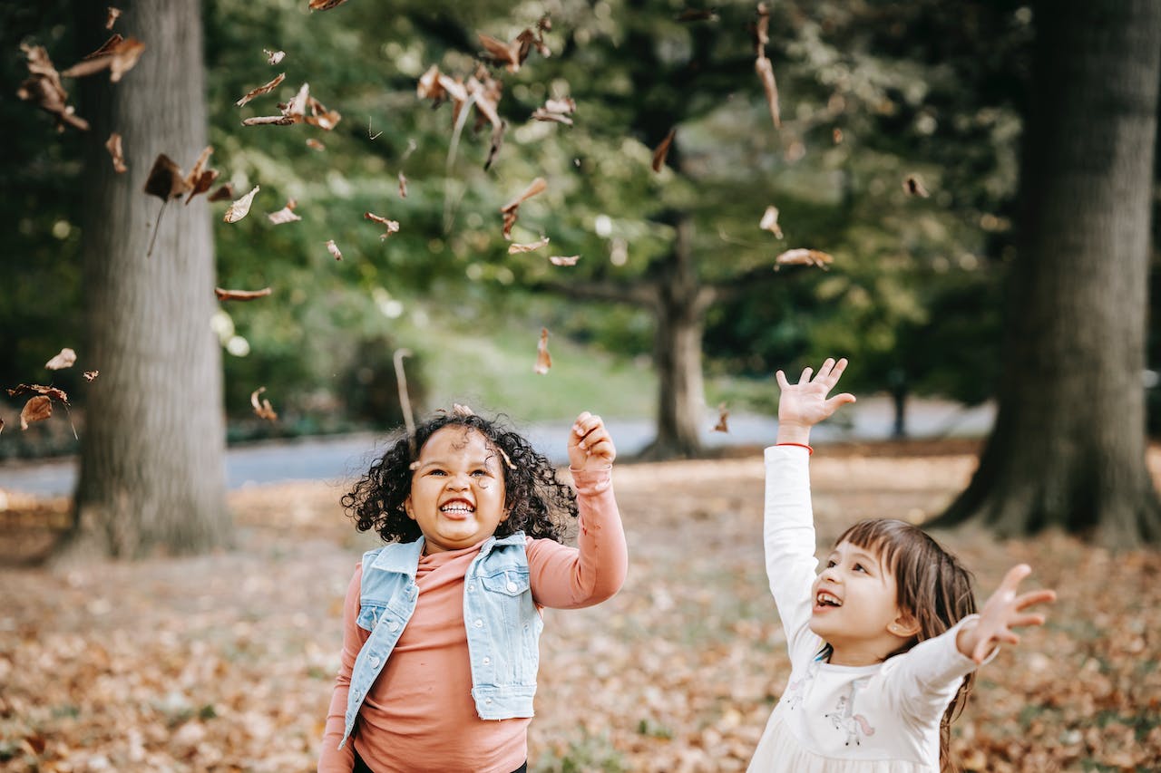 enfants jetant des feuilles en l'air