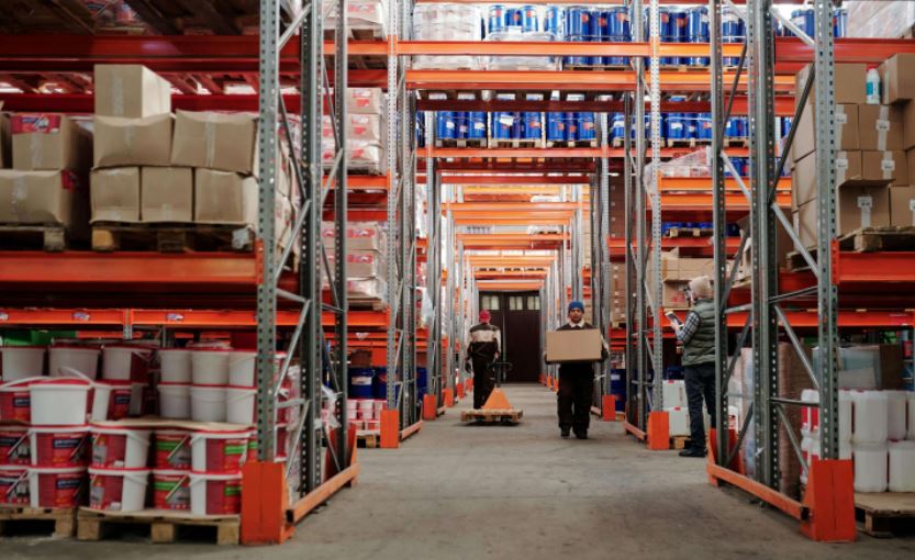 2 agents dans un entrepôt qui préparent des commandes de marchandises