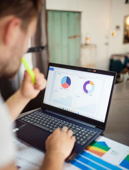 Personne devant son écran d'ordinateur affichant des graphiques