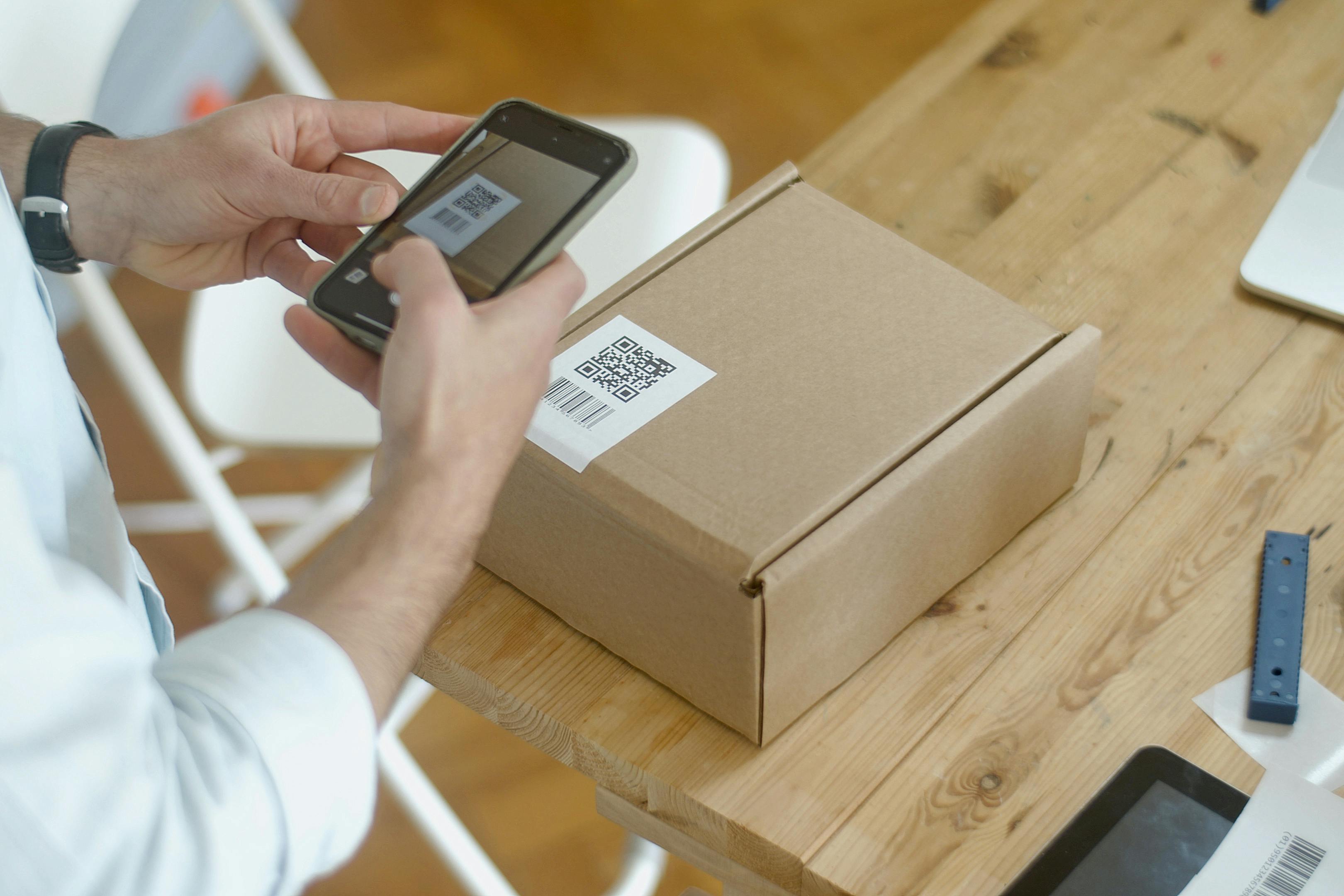 personne scannant le QR Code d'un colis avec son téléphone
