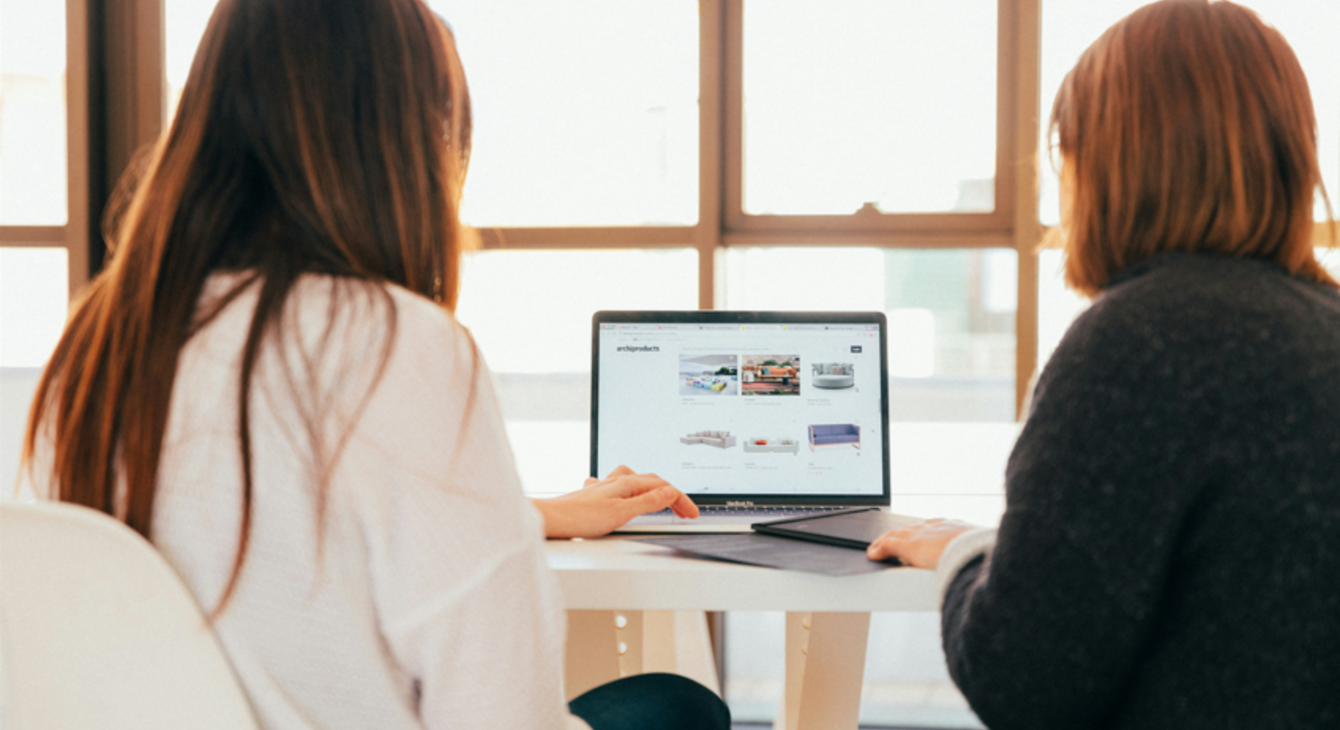 Deux femmes discutent en regardant un ordinateur portable