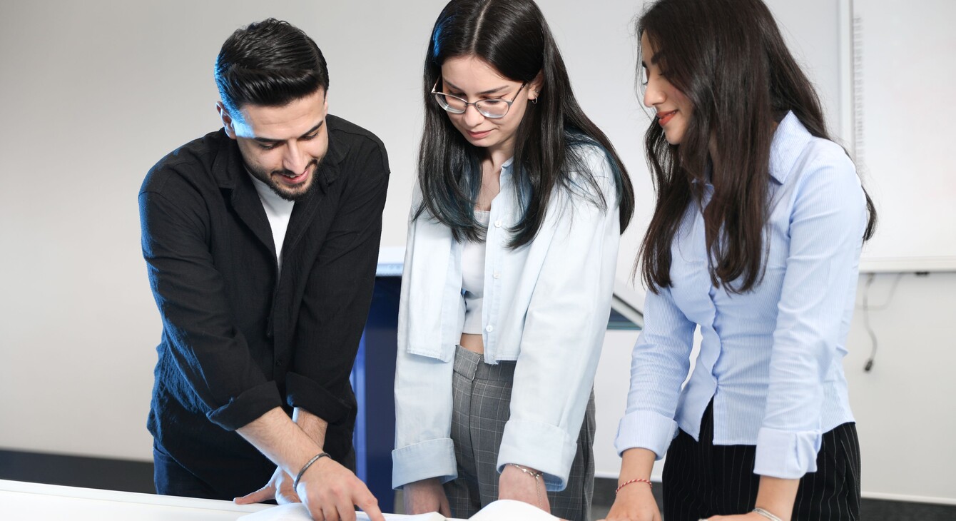 3 personnes regardant un document