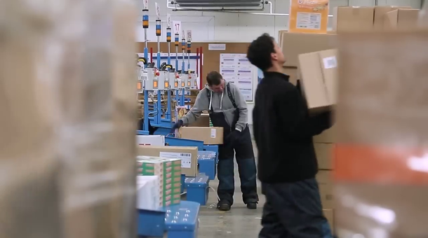 logisticien en train de préparer des colis dans un entrepôt