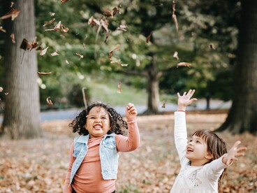 enfants jetant des feuilles en l'air